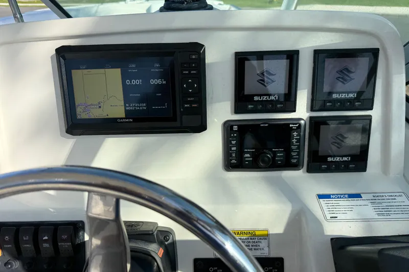 Slide: The Image of Dashboard of a 2014 Carolina Cat 23DC boat with Garmin and Suzuki displays. - 37