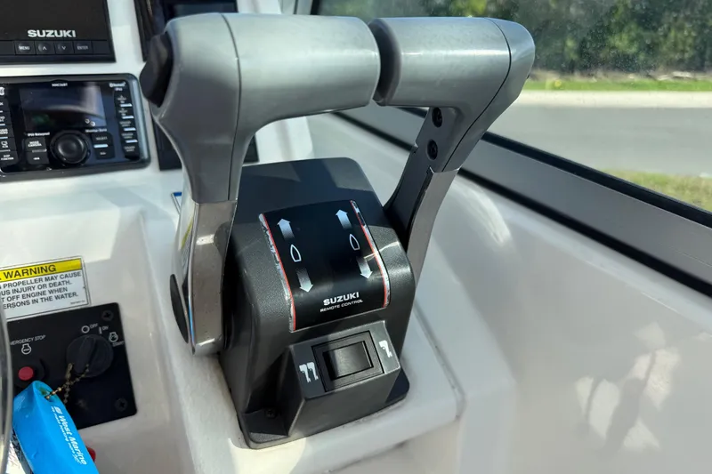 Slide: The Image of Suzuki remote control throttle on 2014 Carolina Cat 23DC boat dashboard. - 40