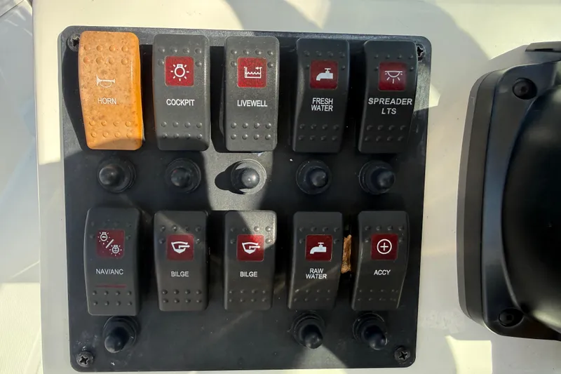Slide: The Image of Control panel of a 2014 Carolina Cat 23DC boat with labeled switches. - 42