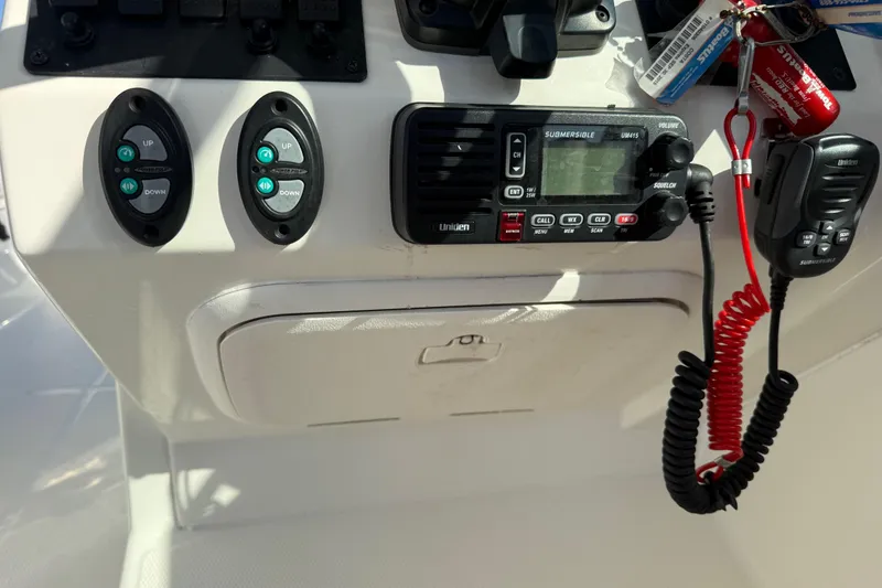 Slide: The Image of Control panel of a 2014 Carolina Cat 23DC boat with radio and switches. - 43