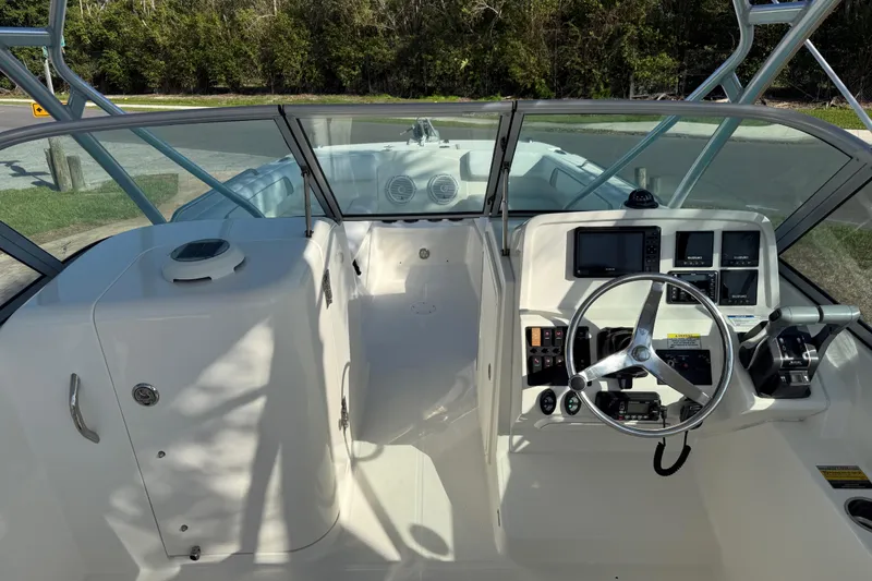 Slide: The Image of 2014 Carolina Cat 23DC boat cockpit with steering wheel and control panel. - 45