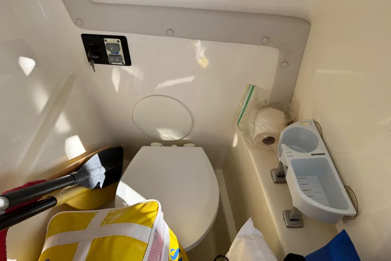 Slide: The Image of 2014 Carolina Cat 23DC boat interior with toilet, storage, and accessories. - 48