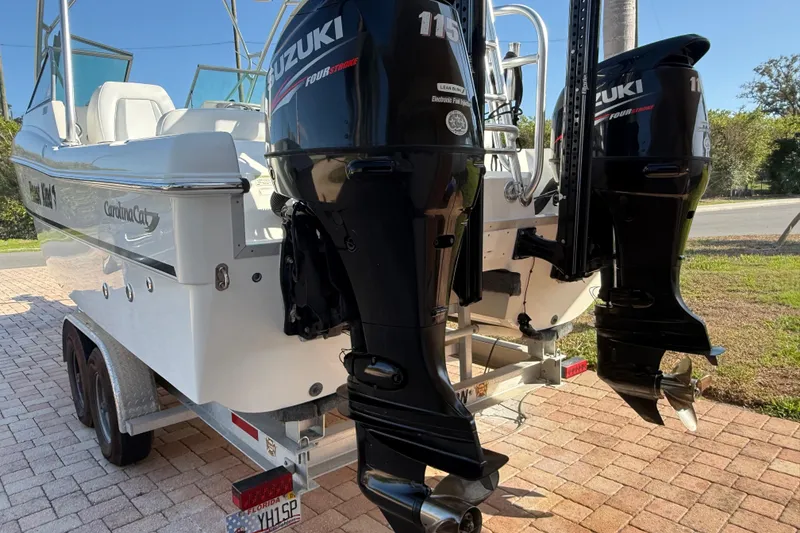 Slide: The Image of 2014 Carolina Cat 23DC boat with dual Suzuki 115 outboard motors on a trailer. - 5