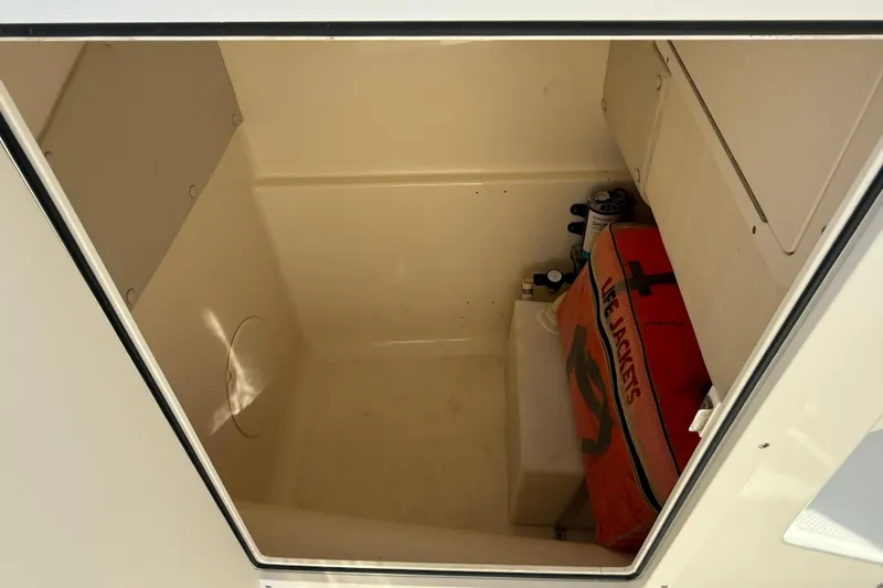Slide: The Image of Storage compartment of 2014 Carolina Cat 23DC boat with life jackets and supplies. - 50