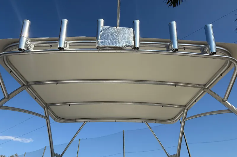Slide: The Image of 2014 Carolina Cat 23DC boat canopy with rod holders against blue sky. - 51