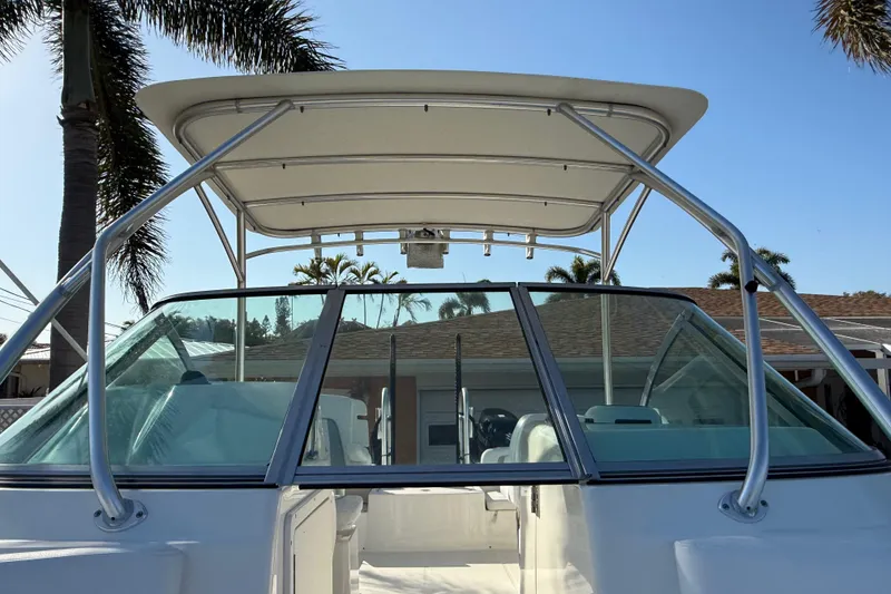 Slide: The Image of 2014 Carolina Cat 23DC boat with T-top and windshield, set against a sunny backdrop. - 53
