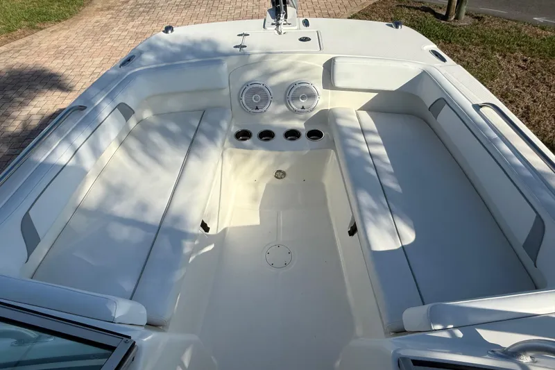 Slide: The Image of 2014 Carolina Cat 23DC boat interior with white seating and cup holders. - 54