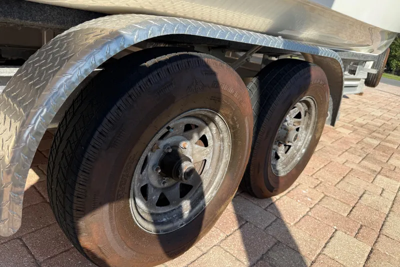 Slide: The Image of Trailer wheels of a 2014 Carolina Cat 23DC on a brick driveway. - 63