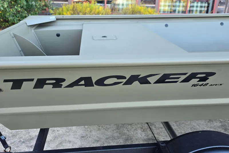 Slide: The Image of 2026 Tracker Grizzly 1648 Utility boat side view with logo and trailer. - 3