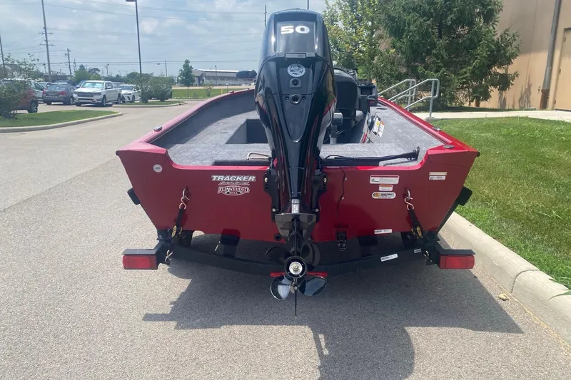 Slide: The Image of 2026 Tracker Super Guide V-16 SC boat with outboard motor, parked outdoors. - 5