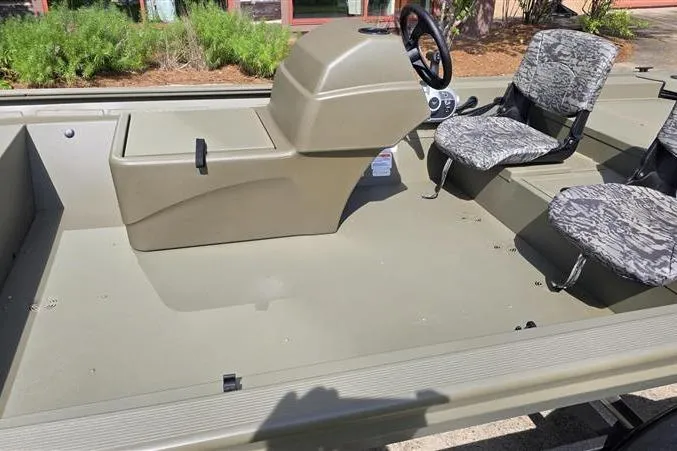 Slide: The Image of 2026 Tracker Grizzly 1754 SC boat interior with steering console and camo seats. - 5