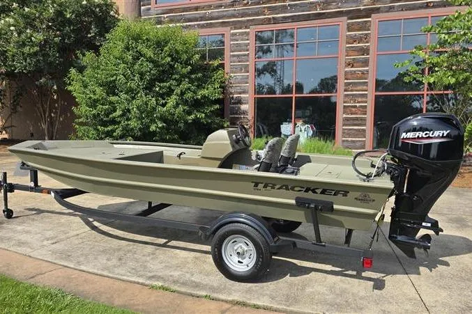 Slide: The Image of 2026 Tracker Grizzly 1754 SC boat with Mercury engine on trailer, parked outdoors. - 2