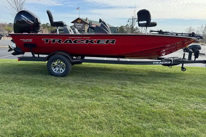 The Image of Red 2026 Tracker Pro Team 195 boat on trailer, parked on grass. - 0