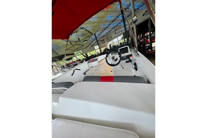 Slide: The Image of 2026 Tahoe T18 boat interior with steering wheel and seating, displayed indoors. - 2