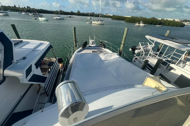 Slide: The Image of 1988 Chris Craft 46 Constellation yacht docked in a scenic marina setting. - 10