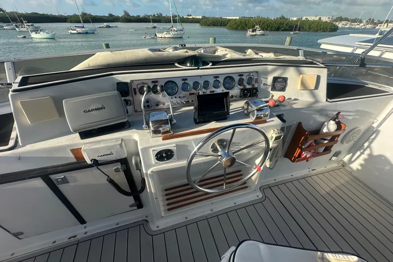 Slide: The Image of 1988 Chris Craft 46 Constellation helm with Garmin navigation, steering wheel, and control panel. - 13