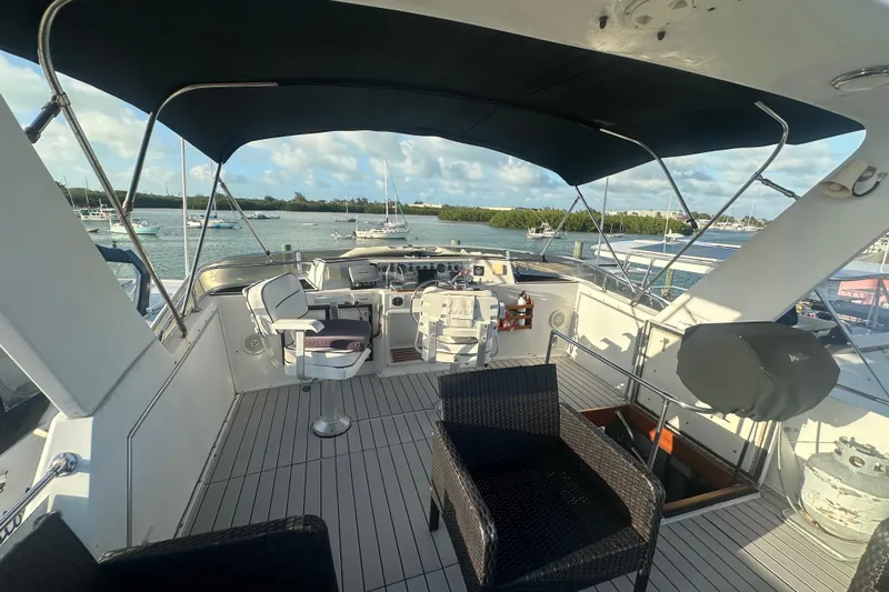 Slide: The Image of 1988 Chris Craft 46 Constellation yacht deck with seating, overlooking marina and boats. - 14