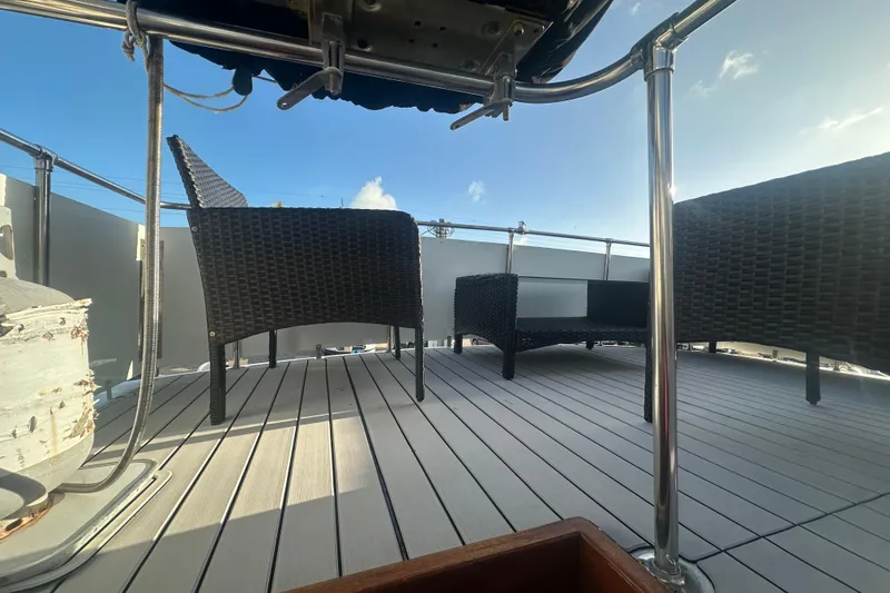 Slide: The Image of 1988 Chris Craft 46 Constellation yacht deck with wicker furniture under a clear sky. - 16