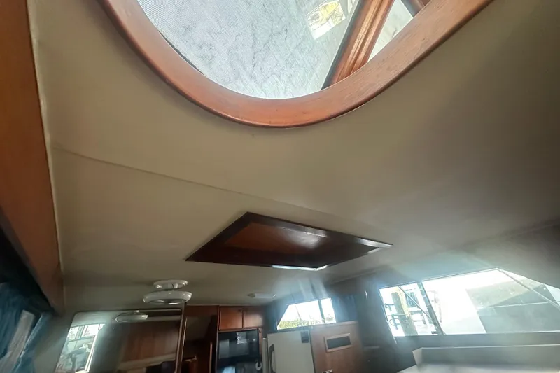 Slide: The Image of Interior view of 1988 Chris Craft 46 Constellation yacht, featuring wooden accents and skylight. - 28