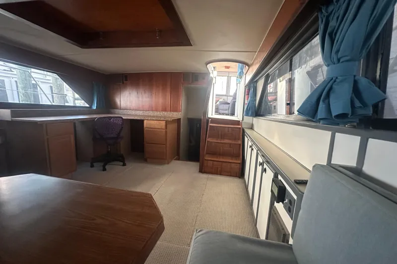 Slide: The Image of 1988 Chris Craft 46 Constellation interior with wood paneling, blue curtains, and carpeted flooring. - 31