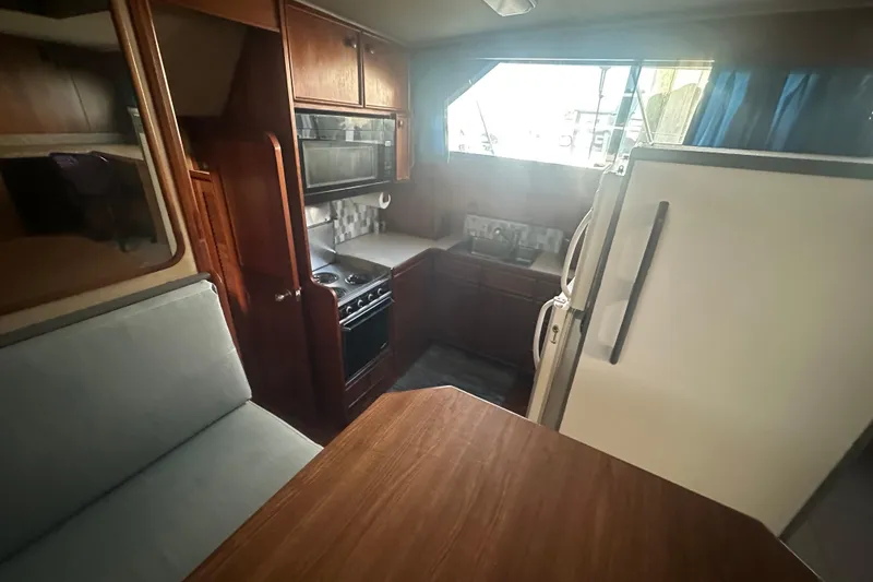 Slide: The Image of 1988 Chris Craft 46 Constellation yacht interior with kitchen and dining area. - 35