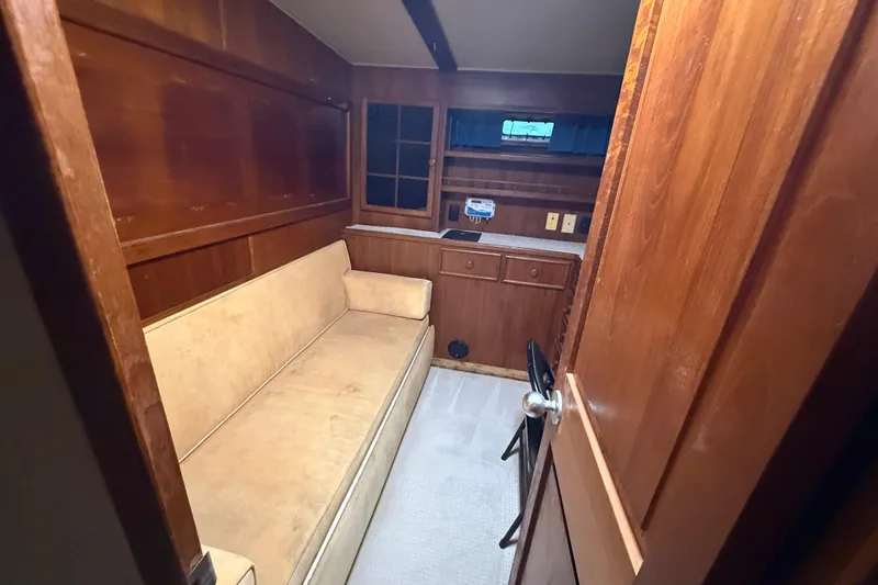 Slide: The Image of 1988 Chris-Craft 46 Constellation cabin interior with wooden paneling and beige seating. - 44