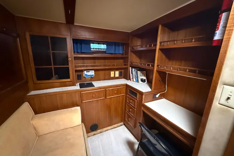 Slide: The Image of 1988 Chris-Craft 46 Constellation interior with wood cabinetry, desk, and seating area. - 47