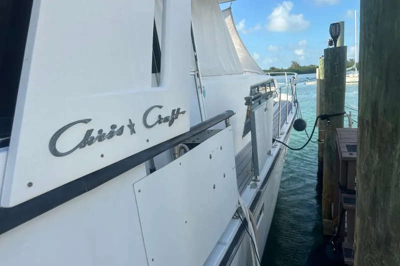 Slide: The Image of 1988 Chris Craft 46 Constellation yacht docked by wooden pier, sunny day. - 5