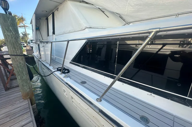 Slide: The Image of 1988 Chris Craft 46 Constellation yacht docked, showcasing sleek design and polished railings. - 7