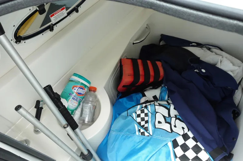 Slide: The Image of Storage compartment in a 2011 Sea Ray 260 Sundeck with life jacket and cleaning supplies. - 13