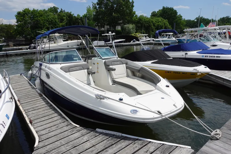 Slide: The Image of 2011 Sea Ray 260 Sundeck boat docked at marina, featuring sleek design and spacious seating. - 3