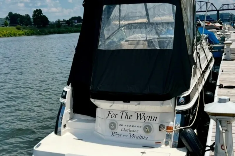 Slide: The Image of 2015 Regal 28 Express boat docked, featuring black canopy and custom name "For The Wynn." - 4