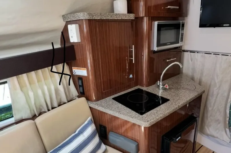 Slide: The Image of Interior of a 2015 Regal 28 Express boat with kitchenette and seating area. - 9