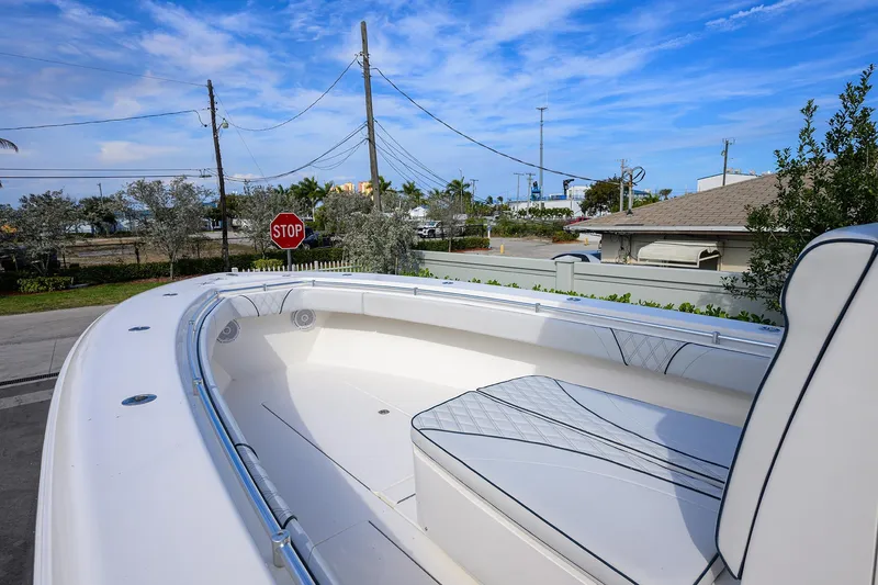 Slide: The Image of 2019 Contender 35 ST boat with sleek seating, parked near a stop sign under a blue sky. - 12