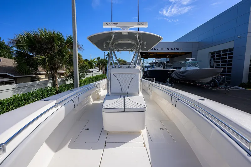 Slide: The Image of 2019 Contender 35 ST boat at service entrance, featuring sleek design and Garmin equipment. - 16