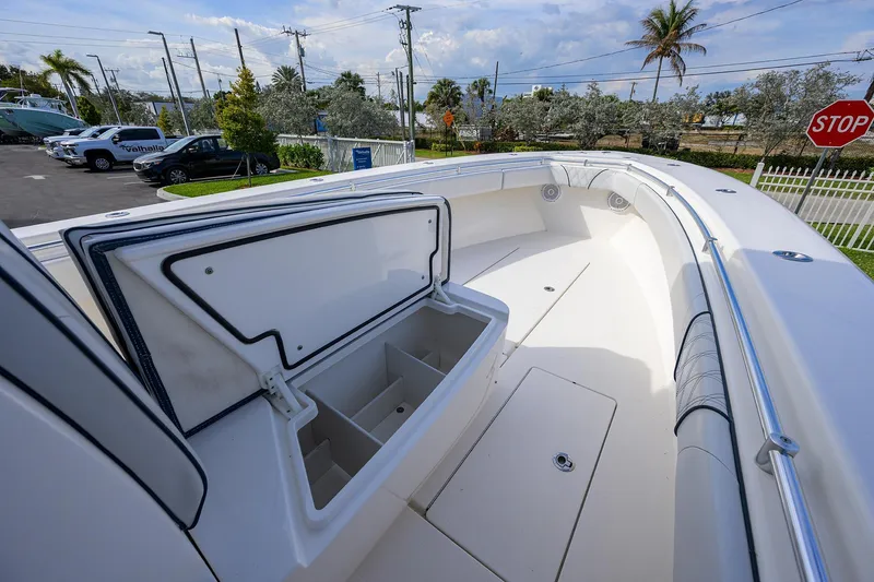 Slide: The Image of 2019 Contender 35 ST boat deck with open storage compartment, parked outdoors. - 20