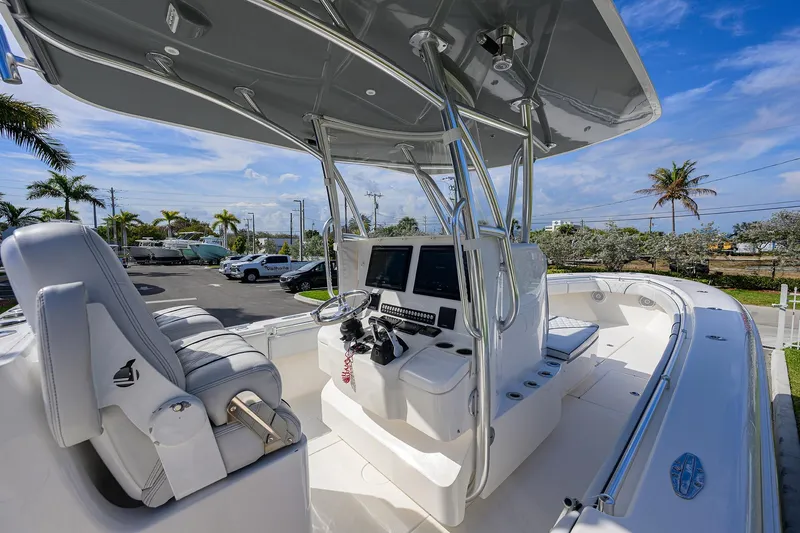 Slide: The Image of 2019 Contender 35 ST boat cockpit with helm, seating, and electronics under a clear blue sky. - 22