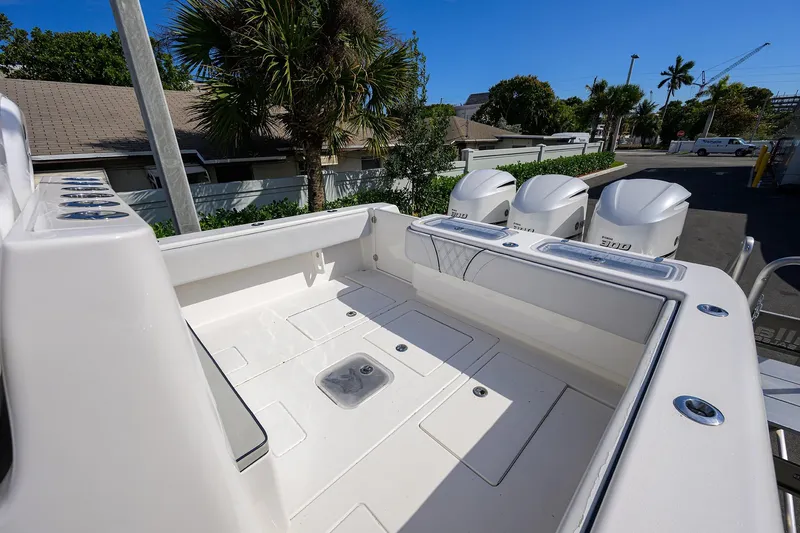 Slide: The Image of 2019 Contender 35 ST boat deck with triple outboard engines, surrounded by tropical foliage. - 24