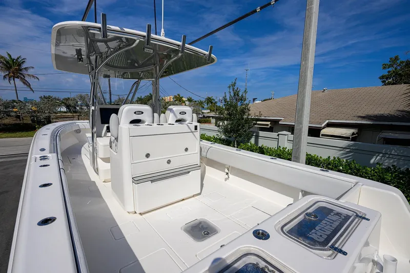 Slide: The Image of 2019 Contender 35 ST boat with T-top and dual helm seats, docked outdoors. - 31