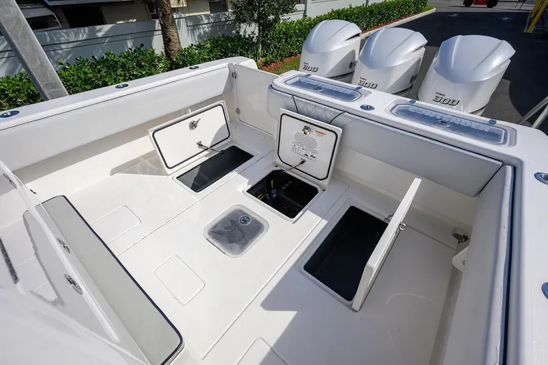 Slide: The Image of 2019 Contender 35 ST boat deck with open storage compartments and triple Yamaha engines. - 35