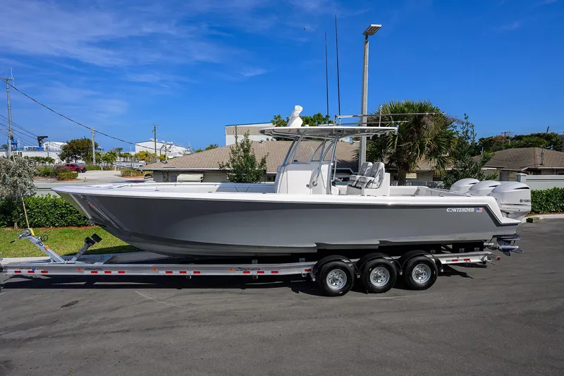 Slide: The Image of 2019 Contender 35 ST boat on trailer, parked outdoors under clear blue sky. - 4
