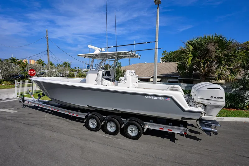 Slide: The Image of 2019 Contender 35 ST boat on trailer, featuring Yamaha engines, parked outdoors. - 5