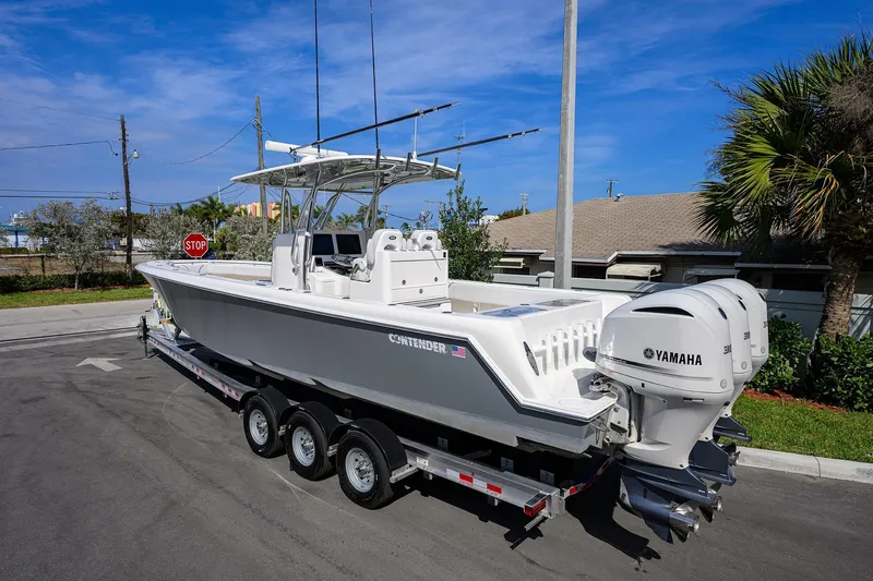 Slide: The Image of 2019 Contender 35 ST boat on trailer with Yamaha engines, parked on a sunny street. - 6