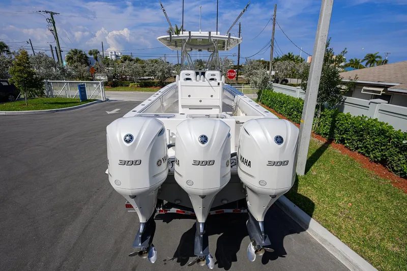 Slide: The Image of 2019 Contender 35 ST boat with triple Yamaha 300 engines, parked on a sunny day. - 7