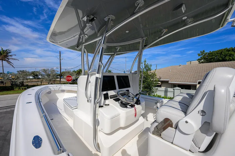 Slide: The Image of 2019 Contender 35 ST boat cockpit with steering wheel and seating under a clear blue sky. - 8