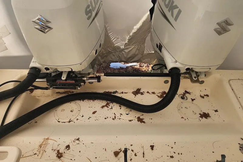 Slide: The Image of Twin Suzuki outboard motors on a 2002 Pursuit 3070 Express boat, surrounded by leaves. - 11