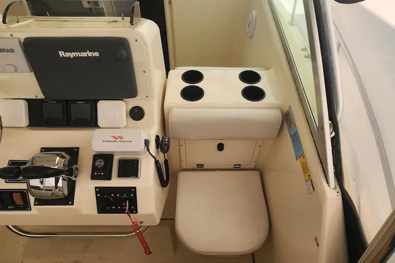 Slide: The Image of 2002 Pursuit 3070 Express boat cockpit with Raymarine equipment and control panel. - 4