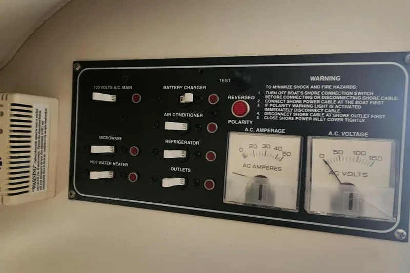 Slide: The Image of Electrical control panel on a 2002 Pursuit 3070 Express boat, showing switches and gauges. - 6
