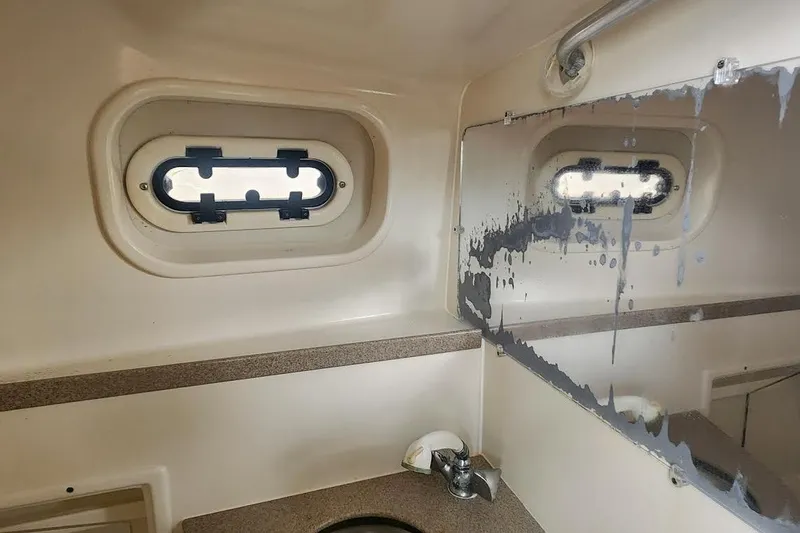 Slide: The Image of Interior of 2002 Pursuit 3070 Express boat bathroom with porthole and mirror. - 7