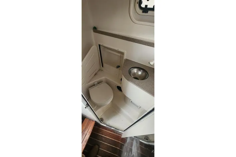 Slide: The Image of Compact bathroom in 2002 Pursuit 3070 Express boat with toilet and sink. - 8